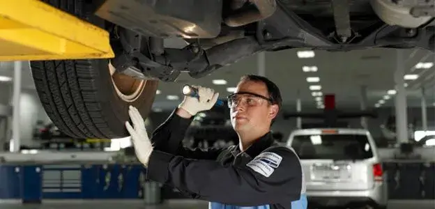 car-service-technician-inspecting-the-car-underneath